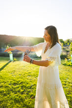 Load image into Gallery viewer, Woman performing a smoke cleansing with sage wand 
