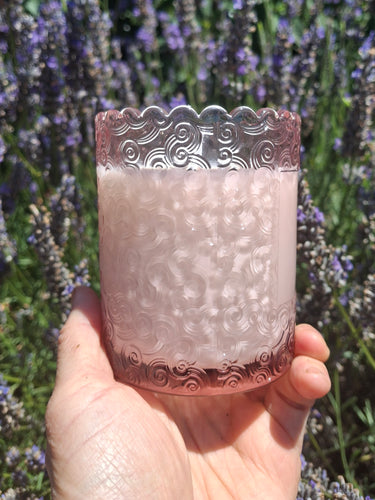 Sweet and simple lavender candle in front of the lavender the oil was made from 